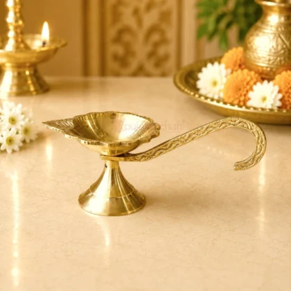 Premium brass handheld pooja diya with engraved long handle and traditional leaf-shaped oil lamp for Aarti, home temple and daily worship.
