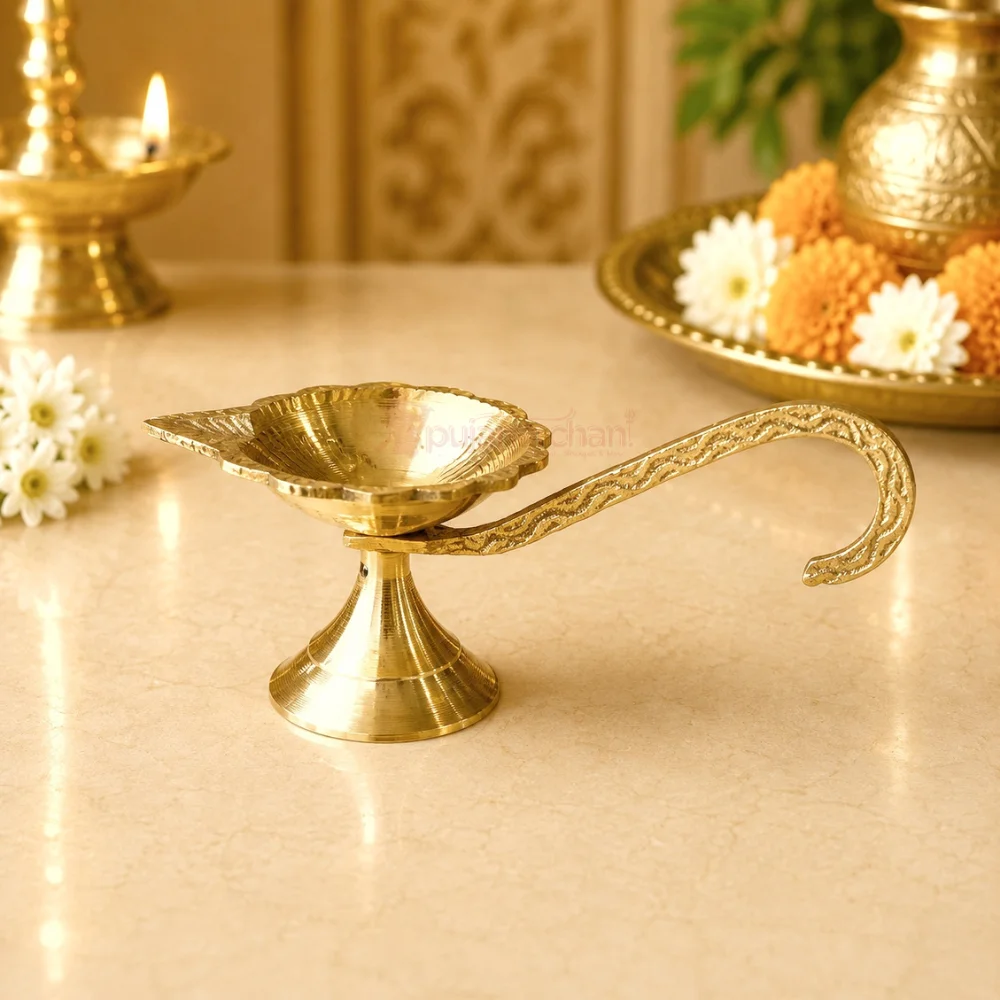 Premium brass handheld pooja diya with engraved long handle and traditional leaf-shaped oil lamp for Aarti, home temple and daily worship.