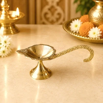 Premium brass handheld pooja diya with engraved long handle and traditional leaf-shaped oil lamp for Aarti, home temple and daily worship.