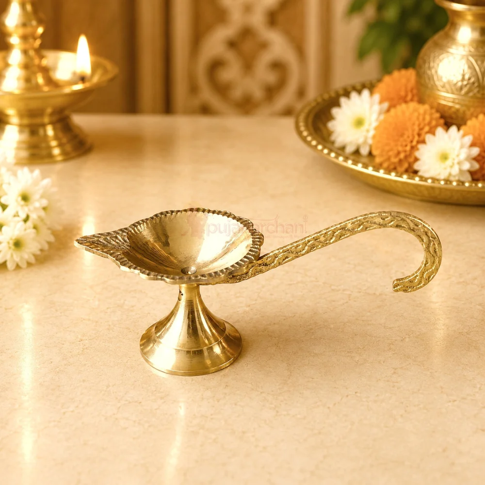 Premium brass handheld pooja diya with engraved long handle and traditional leaf-shaped oil lamp for Aarti, home temple and daily worship.