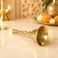 Premium pure brass pooja bell with traditional long handle for home temple, aarti, daily worship and religious ceremonies.