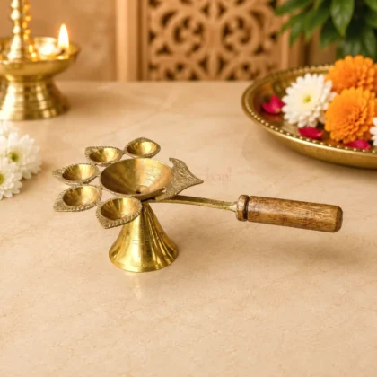 Premium brass Panch Aarti diya with five leaf-shaped oil lamps, central oil bowl and wooden handle for home temple, daily worship and religious ceremonies.